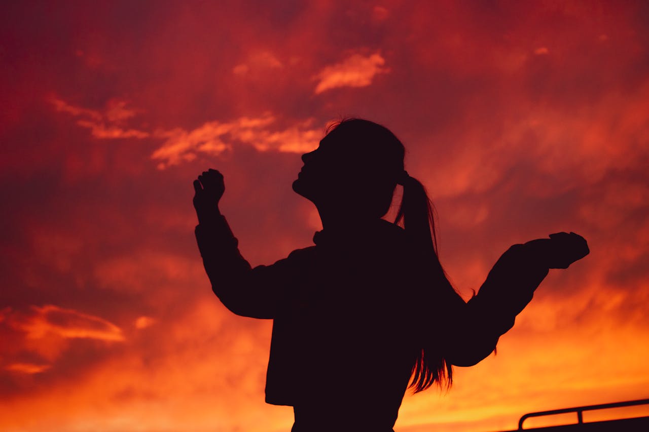 Silhouette of a woman against a red sunset symbolizing emotional overwhelm and depression in Houston