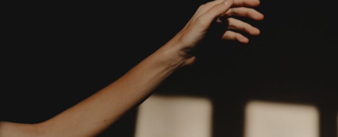 Hand reaching into light representing seeking support for depression in Houston