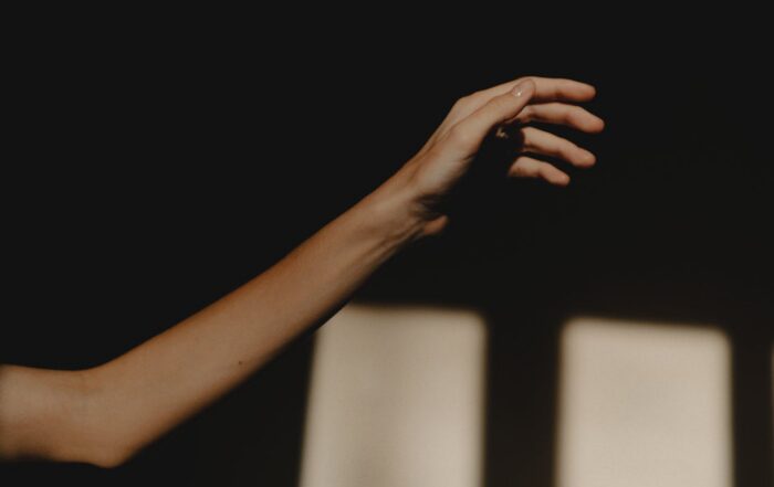 Hand reaching into light representing seeking support for depression in Houston