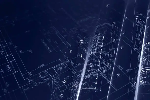 Close‑up of architectural blueprints rendered in white lines on a dark blue background, showing detailed measurements and structural layouts.